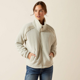 Woman wearing a beige fleece jacket with white trim on a beige background
